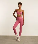 Calza deportiva larga color rosa con cintura alta, bolsillos laterales y franjas blancas en los laterales.
