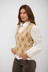 Chaleco tejido de punto con diseño de rombos en tonos beige y marrón, cuello en V y terminaciones acanaladas.