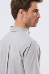 Camisa sport celeste de manga corta con cuello abotonado y bolsillo frontal en el pecho.