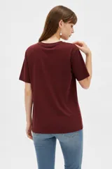 Remera de algodón de manga corta y cuello redondo, con corte holgado y estampado frontal con la frase "NOTHING IS REAL".