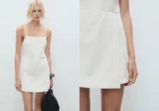 Vestido corto de algodón estilo denim con diseño sin mangas, tirantes finos, cuello escotado y cierre de cremallera lateral.