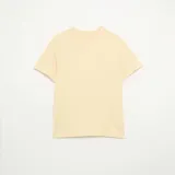 Remera lisa de corte holgado, color amarillo claro, con mangas corta y cuello redondo.