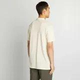 Remera tipo polo color crema, de piqué de algodón, con cuello clásico, tapeta de dos botones y bolsillo de parche en el pecho.