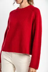 Sweater de lana color rojo, con cuello redondo, mangas largas y detalle de costura decorativa en los laterales.