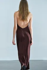 Vestido midi de tejido satinado en color marrón oscuro, con cuello halter de escote fluido, hombros descubiertos y cierre posterior con botones.