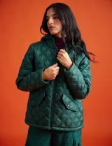 Campera capitoneada azul marino con capucha desmontable, cierre metálico central, bolsillos delanteros y avíos metálicos con logo de la marca Michael Kors.
