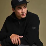 Sweater negro de punto con cuello alto y medio cierre metálico.