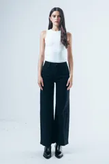 Jean wide leg negro de tiro alto, con paneles laterales en el ruedo que aportan mayor amplitud y movimiento.