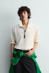 Polo de manga larga color rojo, confeccionado en tejido de algodón con estructura piqué, cuello solapa y cierre frontal de botonadura. Presenta aberturas laterales en el bajo.