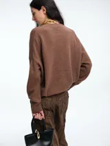 Sweater de tejido de punto en color rosa claro con motas de colores, de corte holgado, cuello redondo y mangas largas con hombros caídos.