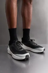 Zapatilla deportiva de correr color caqui, con capellada de tejido de punto transpirable y ajuste con cordones. Cuenta con refuerzos Shield Protect Max en puntera y talón, tirador trasero, plantilla OrthoLite® y entresuela Spume Foam V3.