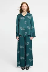 Pantalón ancho de seda viscosa color verde petróleo con estampado de tigres blancos. Cuenta con bolsillos laterales y elástico en la cintura.