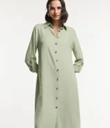 Vestido chemise largo color verde menta, confeccionado en viscolino de marca Marfinno. Presenta cuello solapa, cierre frontal de botones contrastantes, manga larga con trabilla (martingale) y aberturas laterales en el bajo.