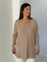 Sweater de punto color visón con cuello en V, mangas largas con puños acanalados y bolsillos frontales tipo parche.