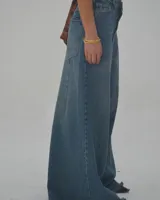 Pantalón de jean celeste de corte ancho con cintura alta y ruedo desflecado.