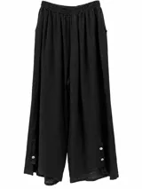 Pantalón negro de lino, de corte holgado y pernera ancha, con cintura elástica fruncida y detalles de botones en el dobladillo inferior.