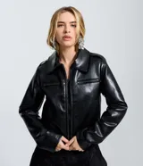 Campera de cuero sintético (PU) color negro, con cuello inglés, cierre frontal por cremallera y bolsillos laterales con cierre en el pecho. Presenta un diseño regular con mangas largas.