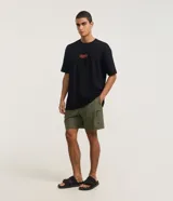 Bermuda masculina confeccionada en tejido ripstop color verde militar, con cintura elástica, cordón de ajuste y un bolsillo lateral con cierre.