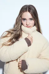 Campera puffer de corderito negro con cuello alto y diseño oversized. Presenta una textura tipo teddy, cierre frontal y corte a la cintura.