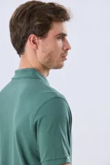 Remera polo de piqué de algodón color azul, de manga corta, con cuello camisero, cierre frontal de dos botones y pequeño logo bordado en el pecho.