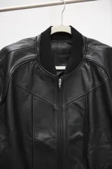 Campera tipo bomber confeccionada en cuero ovino, con cuello tejido acanalado y cierre frontal completo.