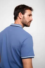 Remera polo blanca de corte regular, con cuello y mangas con detalles de doble línea en azul y negro.