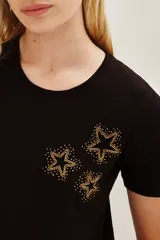 Remera de algodón color negro, de corte clásico y manga corta, con detalle de estrellas bordadas en hilo dorado y pequeñas aplicaciones brillantes en el pecho.