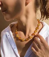 Collar corto compuesto por cuentas facetadas de cristal checo en tonos ámbar y miel, alternadas con pequeñas cuentas esféricas doradas.