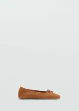 Zapato tipo bailarina de ante color marrón, con punta redonda y lazo decorativo en el empeine.