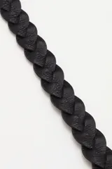 Cinturón de cuero vacuno trenzado en color negro, con hebilla metálica plateada de diseño rectangular con detalles de tachas.