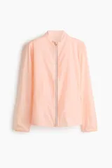 Campera de correr liviana color salmón, de corte estándar con cuello elevado, cierre frontal y tecnología DryMove para absorber el sudor.