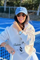Gorra tipo baseball de color azul con efecto lavado, con bordado frontal de un escudo con una piña en el centro.