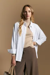Polera de tejido acanalado con cuello alto, corte ajustado al cuerpo y mangas tres cuartos con terminaciones onduladas en los puños.