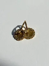 Aros de acero quirúrgico con dije circular de resina rosa y borde de strass dorados.