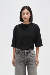 Remera de corte holgado, color negro, con cuello redondo y mangas cortas.