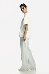 Remera oversized blanca de punto de algodón, con cuello redondo, mangas cortas y estampa tipográfica frontal con la inscripción "The Bellavista".