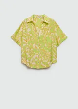 Camisa de manga corta con estampado floral en tonos verde y amarillo. Diseño oversize con cuello camisero y cierre frontal con botones.