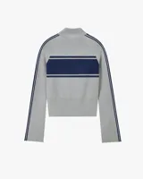 Jersey de punto con cierre frontal de cremallera y cuello alto. Presenta un diseño bicolor en gris y azul marino, con franjas horizontales en el pecho, detalles laterales en las mangas y logo de cerezas bordado.