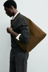 Bolso de hombro liso color verde militar, con compartimento principal con cierre de imán y un bolsillo interior con cremallera. Tiene un asa de hombro.