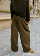 Pantalón wide leg de tiro medio en color verde militar, con diseño de pinzas, trabillas y bolsillos laterales. Cuenta con cierre delantero oculto.