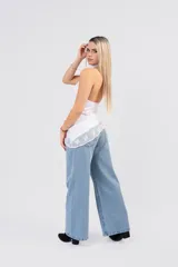 Polera de seda con lycra color blanco, de cuello alto y espalda descubierta. Presenta un diseño asimétrico en la parte inferior con un detalle de encaje sutil en el ruedo.
