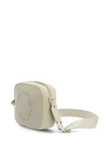 Cartera bandolera Hush Puppies de diseño rectangular con esquinas redondeadas, color beige, confeccionada en material sintético con perforaciones en forma circular que forman el texto de la marca. Cuenta con correa ajustable de lona y cierre superior.