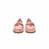 Mocasín plano de cuero color rosado, con punta redondeada y taco bajo. Presenta un detalle artesanal de tiras entrelazadas en tonos nude, verde y rosado alrededor del empeine, rematado con un aplique colgante central con piedra transparente.