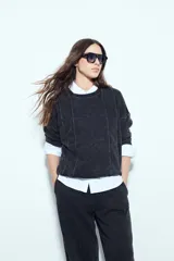 Buzo negro con efecto lavado y costuras verticales a la vista, de calce relajado.