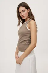 Musculosa de algodón con elastano, de textura acanalada y calce al cuerpo, color marrón topo con cuello redondo y sisas amplias.