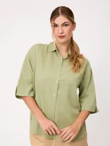 Camisa de manga corta celeste, confeccionada en mezcla de algodón y lino, con cuello camisero y cierre frontal de botones.