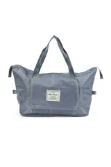 Bolso de viaje color azul confeccionado en poliéster, con bolsillo frontal con cierre y funda para asa de maleta en la parte posterior. Posee doble asa superior y base expandible con cierre.