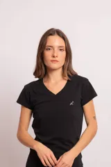 Remera básica negra de algodón con spandex, corte entallado, escote en V y mangas cortas. Presenta un pequeño bordado minimalista en blanco en el pecho.