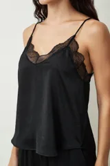 Blusa de tirantes finos en color negro, confeccionada en satén con sutiles brillos, destacando por un delicado detalle de encaje en el escote en V.