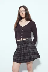 Minifalda tableada con estampado de cuadros en tonos oscuros, de corte acampanado y estilo colegial.